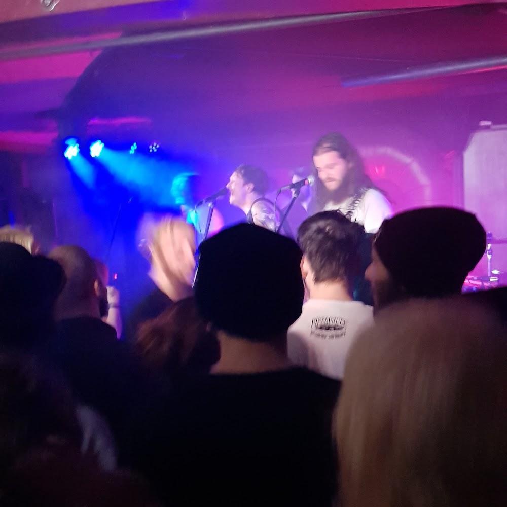 A band plays in a dimly lit venue.